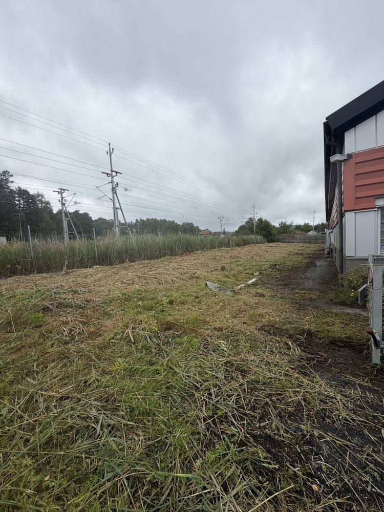 Röjd yta längs industribyggnad
